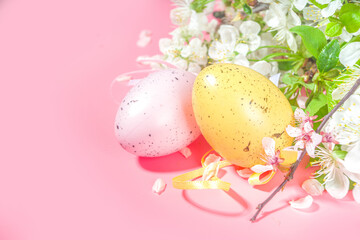 Happy Easter Spring Holiday Greeting Card Background with Easter colorful eggs, decorative bird nests and blossom spring garden flowers, flatlay copy space on high-colored pink background