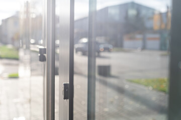 The front door of a office block, reflecting buildings in the glass