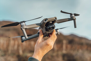 A man holding a drone in his hand ready to fly