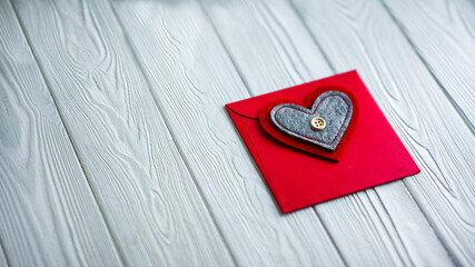 Fototapeta na wymiar Red envelope with hearts. There is a button on the heart. Envelope on a white background. Valentine's Day.