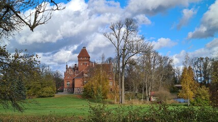 Beautiful old Latvian castle Jaunmoku among trees with yellowed leaves October 16, 2021
