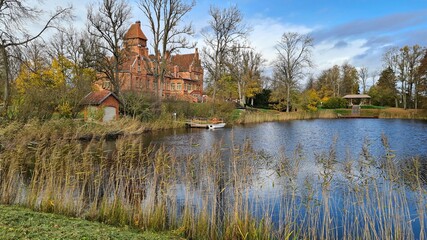Fototapeta premium Beautiful old Latvian castle Jaunmoku among trees with yellowed leaves October 16, 2021
