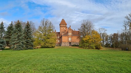 Fototapeta na wymiar Beautiful old Latvian castle Jaunmoku among trees with yellowed leaves October 16, 2021