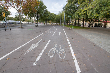 Barcelona, Spain - November 20, 2021: Cycle path in the city center empty due to the coronavirus pandemic. There are few people and vehicles on the street. Empty city