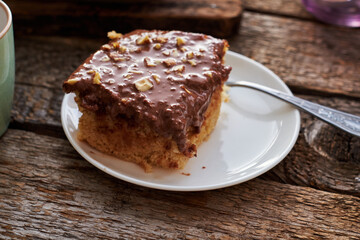 homemade chocolate cake with nuts, side view, wooden background.