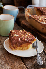 homemade chocolate cake with nuts, side view, wooden background.
