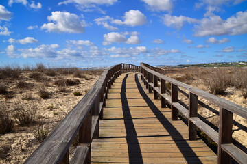 Fototapeta na wymiar Wooden boardwalk crossing marshes, Alvor, Algarve, Portugal