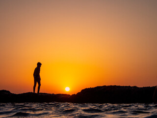 Fototapeta na wymiar tramonto sul mare sagoma di un ragazzo 638