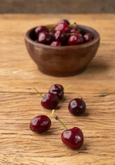 Red cherries on a bowl over wooden table