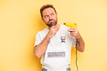 middle age man thinking, feeling doubtful and confused. handyman and repair concept - obrazy, fototapety, plakaty