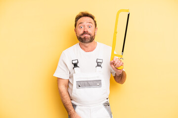 middle age man shrugging, feeling confused and uncertain. handyman and repair concept