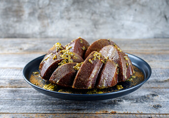 Exotically bundt marble passion fruit rum cake with icing sugar glaze, fresh fruit pulp topping and muscovado brown sugar served as close-up on a plate with copy space