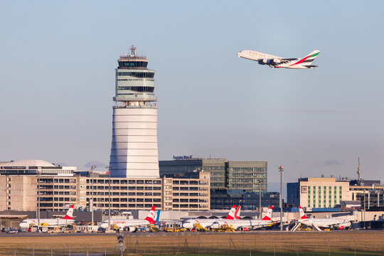 view of airport vienna with control tower, terminal, airplanes and apron