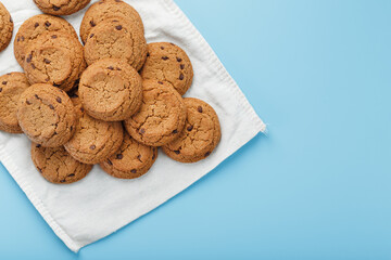 Oatmeal cookies on a blue background and a white napkin top view