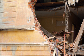 Thick brick ruined wall of the house. Demolition of dilapidated housing, renovation