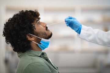 Closeup of indian guy having nasal swab test, COVID-19 diagnostic