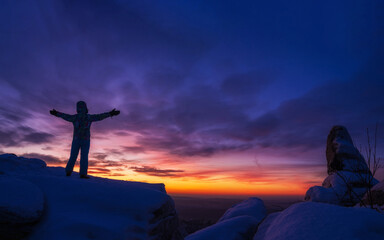Obraz premium Silhouette of a man with hands raised in the beautiful sunset.