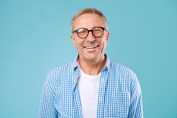 Fototapeta Portrait of smiling mature man in glasses posing at studio obraz