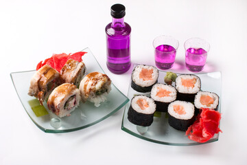 Rolls with tuna and smoked eel. Bottle of sake with glasses alcoholic drink