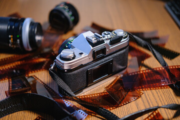 Fototapeta na wymiar 35mm film camera on wood with film and lenses