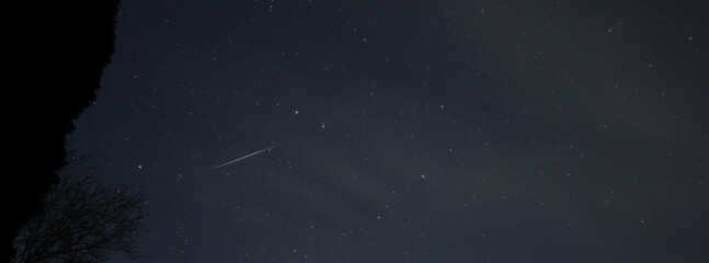 Quadride 2022 night sky a meteorite streaks through the stars at night.