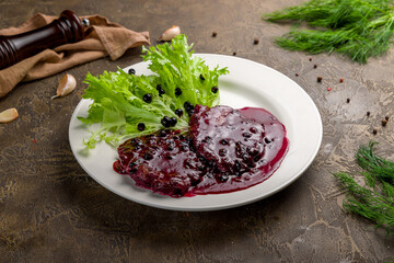 meat with black currant sauce on white plate