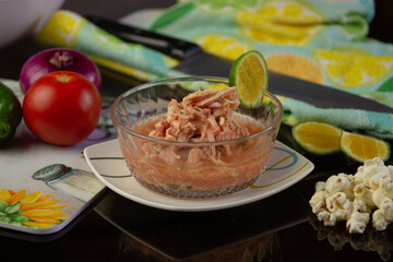 primer plano de plato de ceviche de pollo con rodaja de limón 