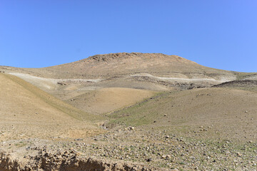 Stone Desert on the West Bank. Judean Desert in clear weather. White sand dunes and blue sky. Stony desert in the spring, green grass. Sand Hills of Judean Mountain, Israel. 
