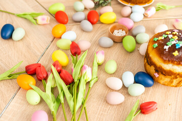 Easter cake and colorful eggs and flowers on the foreground