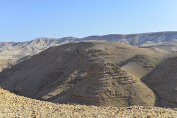 Stone Desert on the West Bank. Judean Desert in clear weather. White sand dunes and blue sky. Stony desert in the spring, green grass. Sand Hills of Judean Mountain, Israel. 