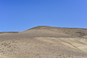 Stone Desert on the West Bank. Judean Desert in clear weather. White sand dunes and blue sky. Stony desert in the spring, green grass. Sand Hills of Judean Mountain, Israel. 