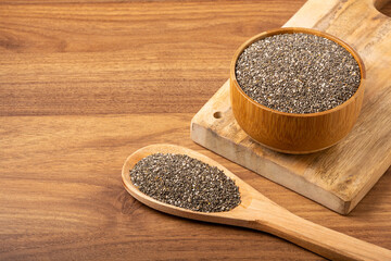 Chia seeds in wooden bowl and wooden spoon.