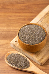 Chia seeds in wooden bowl and wooden spoon.