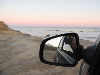 mirar el mar desde el auto sacando fotos al atardecer