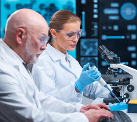 Professor and doctor work in a modern scientific laboratory using equipment and computertechnologies. Group of scientists make research and develop new vaccines. Science and healthcare concept.