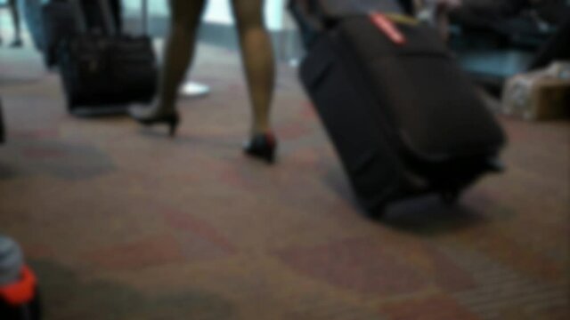Blurred defocused stewardess boarding and entering the airplane to take their flight. Flight attendants walking with suitcases and red dress inside of airport terminal