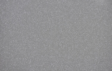 Dark gray monochrome background with a scattering of small silvery blotches.