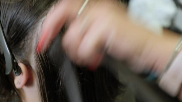 A hairdresser grinds a woman. Women's haircut in a beauty salon