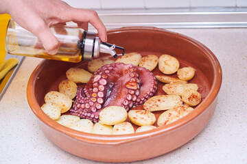 closed shot cooking baked octopus with potatoes, olive oil and paprika typical and healthy food