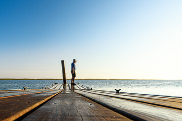 person on the pier staring into the distance, searching for the meaning of life?