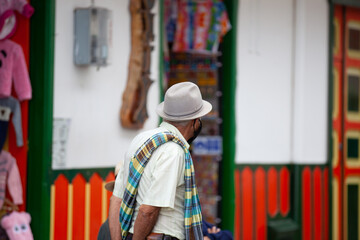 Senior local man wearing traditional poncho and hat at the beautiful streets of Salento an small...