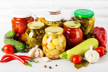 canned food on a white table with vegetables, different types of canned vegetables
