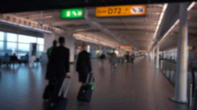 Defocused shot of passengers and stewardess walk in international Airport. People walking for take flight in terminal lounge gates. European airports. Blurred background in the scene