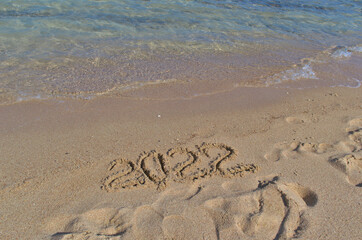Inscription on the sand 2022 on the shores