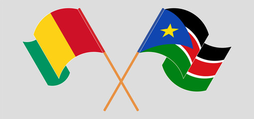 Crossed and waving flags of Guinea and South Sudan