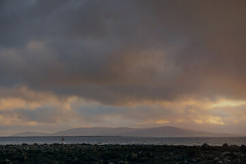 Dramatic cloudy sky with sun beam over calm ocean surface. Peaceful and calm atmosphere