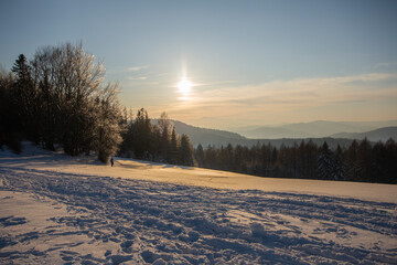 a winter mountain glade in the background the setting sun, mountain mood, Beskid Sądecki