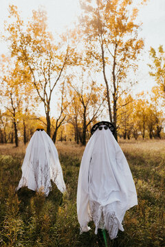 Two people dressed as ghosts looking directly into camera