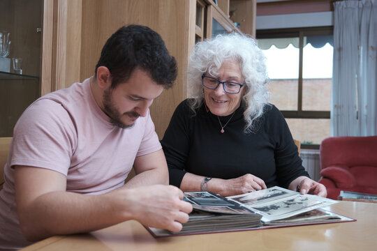 Senior woman reminiscing on old memories with her son.