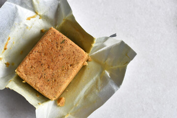 A top view image of a chicken bouillon cube in a silver wrapper. 